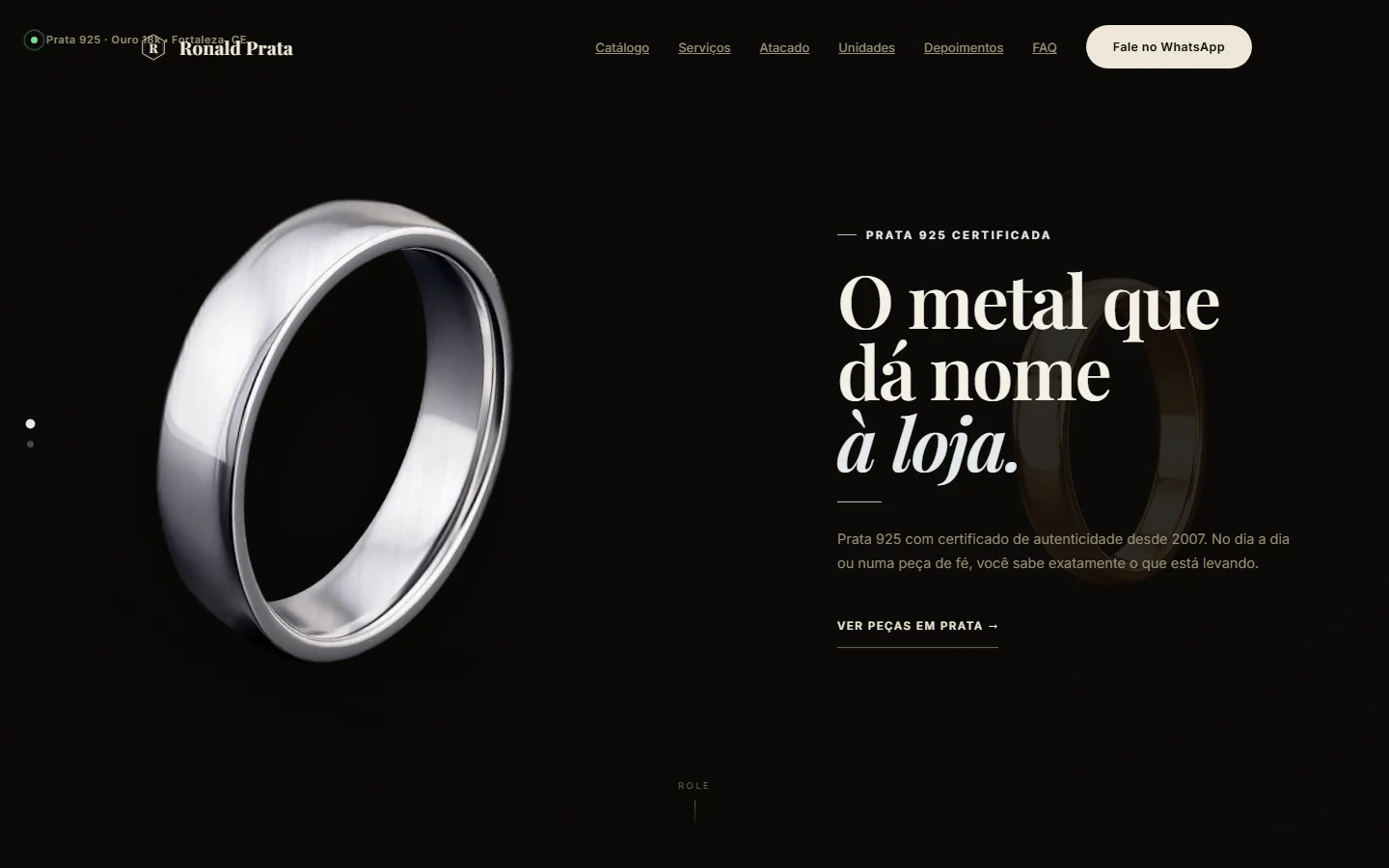 Hero do conceito: anel de prata à esquerda sobre fundo quase preto, ao lado do título "O metal que dá nome à loja"